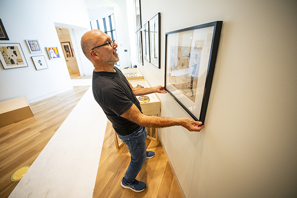 Rafael Chacon hangs art at the Montana Museum of Art and Culture