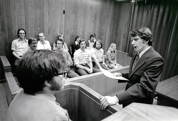 A law student approaches the stand in a mock trial.