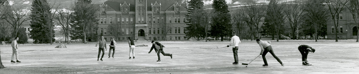 Archival photo of students playing hockey on the ice-covered oval.