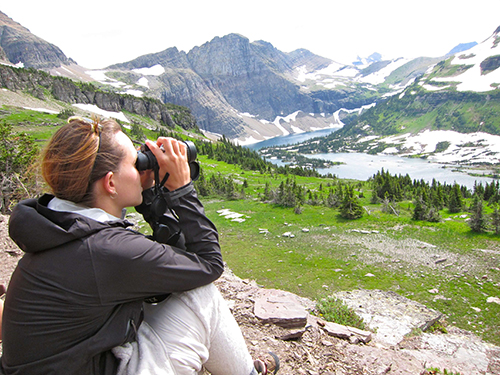 A student looks across a canyon through binoculars
